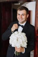 retrato do uma jovem noivo às casa antes a Casamento cerimônia. uma bonito homem vestido dentro uma clássico terno. masculino retrato. foto