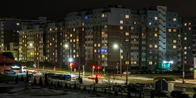 com luz dentro janelas do multistory edifícios às noite. vida dentro uma grande cidade. serenata do luz foto