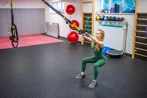 Treinamento dentro a Academia para a figura correção. jovem mulher fazendo ginástica exercícios às academia. foto