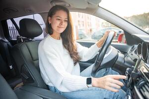 jovem mulher dirigindo uma carro e usando Smartphone inscrição para Visão uma mapa mostrando viagem rota foto