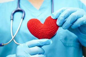 médico de mulher asiática segurando coração vermelho para saúde no hospital. foto