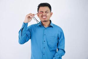 engraçado face jovem ásia homem obteve cutucou dentro a olho com uma óculos vestindo azul camisa isolado em branco fundo foto