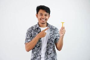 sorridente ou feliz jovem ásia homem apontando às a barbeador com dele dedo vestindo Preto camisa isolado em branco fundo foto