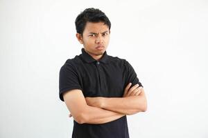 jovem ásia homem dentro casual Preto pólo t camisa com braço cruzado cansado do uma repetitivo tarefa olhando às Câmera estúdio tiro isolado em branco fundo foto