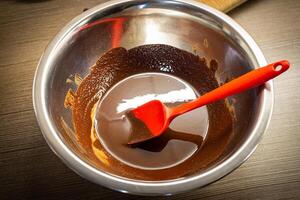 mulher cozinhando saboroso derretido chocolate em mesa dentro cozinha. foto