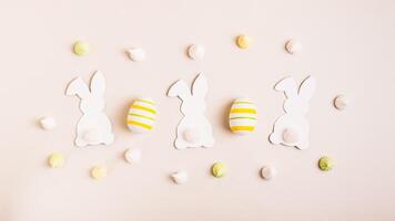 feliz Páscoa branco coelhos, Páscoa ovos e mini merengues em Rosa fundo topo Visão rede bandeira foto