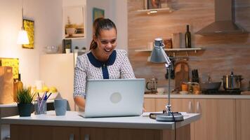 animado mulher sentir em êxtase lendo ótimo conectados notícia em computador portátil trabalhando a partir de casa cozinha. feliz empregado usando moderno tecnologia rede sem fio fazendo hora extra estudando escrita, procurando foto