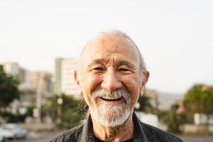 feliz Senior homem sorridente dentro frente do Câmera dentro a cidade - idosos pessoas estilo de vida conceito foto