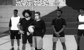 grupo do multirracial pessoas tendo Diversão jogando basquetebol ao ar livre - urbano esporte estilo de vida conceito - Preto e branco edição foto