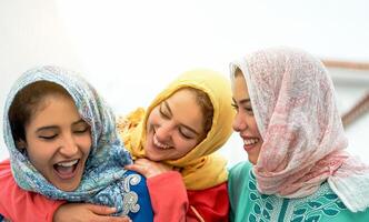 feliz árabe mulheres tendo Diversão dentro a cidade - jovem muçulmano meninas gastos Tempo e rindo juntos ao ar livre - conceito do juventude estilo de vida pessoas, cultura e religião foto