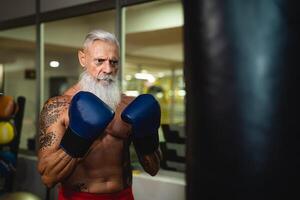 Senior homem boxe dentro esporte Academia Centro clube - saúde ginástica e desportivo atividade conceito foto