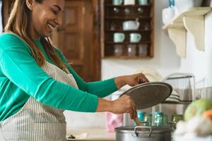 latim maduro mulher cozinhando dentro velho vintage cozinha - sorridente mãe preparando lançamento às casa foto