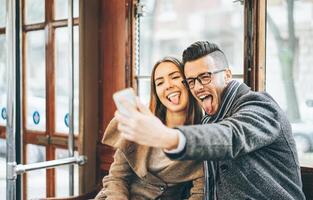 feliz jovem casal levando fotos usando Móvel inteligente telefone Câmera dentro ônibus - viagem amantes fazer uma auto retrato para postar em social meios de comunicação rede - relação, amor, Smartphone vício conceito