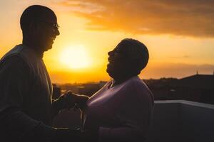 feliz latim Senior casal tendo romântico momento dançando em telhado durante pôr do sol Tempo foto