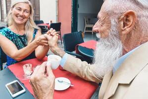 feliz Senior casal bebendo café sentado dentro uma Barra - moda maduro marido e esposa olhando cada de outros enquanto tendo pausa dentro uma restaurante - pessoas, felicidade, amor e casamento conceito foto