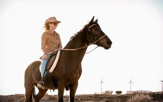 jovem mulher equitação uma cavalo dentro curral rancho foto