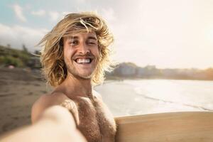 jovem surfista homem levando selfie enquanto tendo Diversão surfar em ensolarado dia - juventude pessoas estilo de vida e extremo esporte conceito foto
