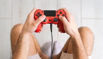 jovem homem jogando conectados vídeo jogos - fechar acima masculino mãos jogador tendo Diversão em Novo tecnologia console - jogos entretenimento e juventude milenar geração estilo de vida conceito foto