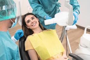 homem dentista operativo jovem sorridente mulher dentro dental clínica - oral saúde assistência conceito foto