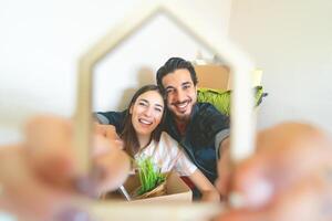 feliz jovem casal comovente dentro Novo casa primeiro Tempo - homem e mulher tendo Diversão desembalar cartão caixa dentro Novo propriedade casa - mudança apartamento dia e pessoas estilo de vida relação conceito foto