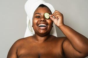 feliz cheio de curvas africano mulher tendo pele Cuidado spa dia - pessoas auto Cuidado estilo de vida conceito foto