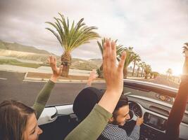 feliz amigos tendo Diversão dentro conversível carro em período de férias - jovem na moda pessoas dirigindo em cabriolet auto dentro verão estrada viagem feriados - transporte e juventude geração estilo de vida conceito foto