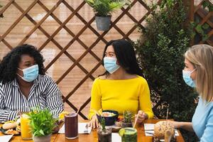 multirracial amigos tendo saudável almoço dentro café Escovar Barra durante corona vírus surto foto
