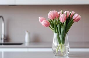 ai gerado Rosa tulipas arranjado dentro uma vidro vaso, adornando uma cozinha contador. foto