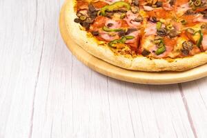 delicioso ampla pizza com vitela e cogumelos em uma luz de madeira fundo foto