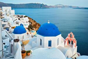 famoso Visão a partir de ponto de vista do santorini oia Vila com azul cúpula do grego ortodoxo cristão Igreja foto