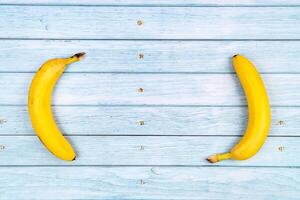 amarelo bananas mentira em uma azul de madeira background.summer conceito foto