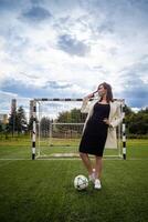 retrato do uma lindo mulher futebol jogador dentro uma rigoroso escritório terno. foto