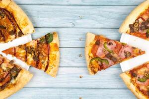 dois diferente delicioso grande pizzas em uma azul de madeira fundo foto