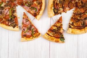 dois diferente delicioso ampla pizzas em uma luz de madeira fundo foto