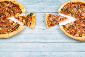 dois diferente delicioso grande pizzas em uma azul de madeira fundo foto
