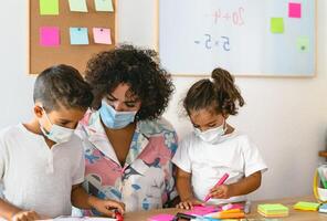 professor com crianças vestindo face mascarar dentro pré escola Sala de aula durante corona vírus pandemia - cuidados de saúde e Educação conceito foto