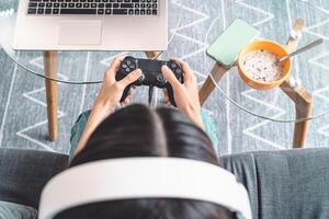 jovem mulher jogando conectados vídeo jogos - topo Visão fêmea jogador tendo Diversão em Novo tecnologia console - jogos entretenimento e juventude milenar geração estilo de vida conceito foto