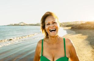 feliz latim Senior mulher tendo Diversão em a de praia durante verão período de férias - idosos pessoas estilo de vida conceito foto