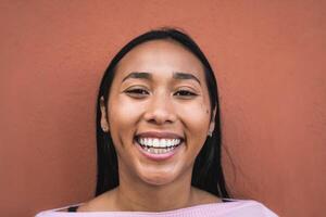 retrato do feliz jovem hispânico mulher sorridente dentro frente do Câmera foto