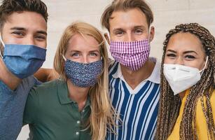 amigos vestindo face protetora mascarar para evitar corona vírus espalhar - jovem milenar pessoas retrato durante coronavírus surto - saúde Cuidado pessoas e juventude multirracial estilo de vida amizade conceito foto