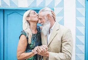 feliz Senior casal tendo concurso momentos ao ar livre - maduro elegante pessoas a comemorar encontro do seus aniversário - esposa se beijando dela marido - conceito do amor e relação idosos estilo de vida foto