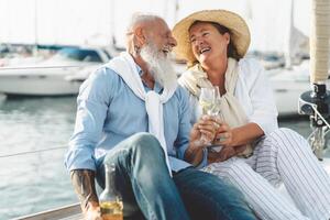 Senior casal brindar champanhe em barco a vela período de férias - feliz idosos pessoas tendo Diversão a comemorar Casamento aniversário em barco viagem - amor relação e viagem estilo de vida conceito foto