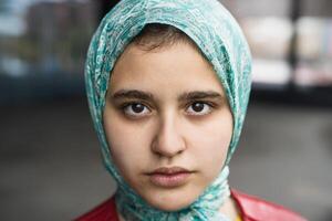 fechar-se retrato do muçulmano menina olhando dentro Câmera foto