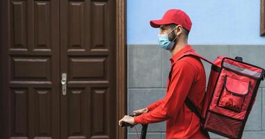 cavaleiro homem entregando refeição com elétrico lambreta dentro a cidade enquanto vestindo face mascarar durante corona vírus surto - ecológico velozes Entrega Comida conceito foto