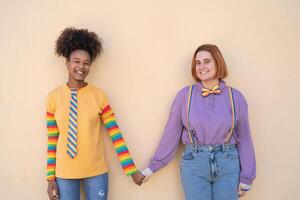feliz mulheres gay casal segurando mãos ao ar livre - lgbt e amor conceito foto