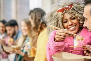 grupo do feliz amigos comendo ásia rua Comida ao ar livre - jovem na moda pessoas tendo Diversão fazendo uma velozes refeição juntos dentro a cidade - conceito do amizade, juventude e rua cidade vida foto