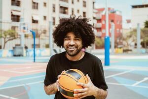 feliz homem jogando basquetebol ao ar livre - urbano esporte estilo de vida conceito foto