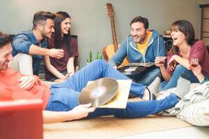 grupo do feliz amigos fazendo festa ouvindo vintage vinil disco às casa - jovem pessoas tendo Diversão bebendo tiros e rindo juntos dentro seus apartamento - amizade, música, juventude estilo de vida feriados foto