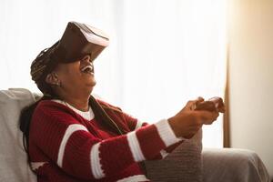 africano Senior mulher tendo Diversão com Novo jogos virtual realidade tecnologia experiência foto
