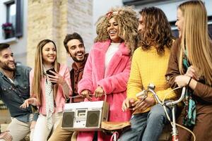 jovem multirracial amigos tendo Diversão ouvindo música com vintage boombox estéreo - juventude milenar estilo de vida conceito foto